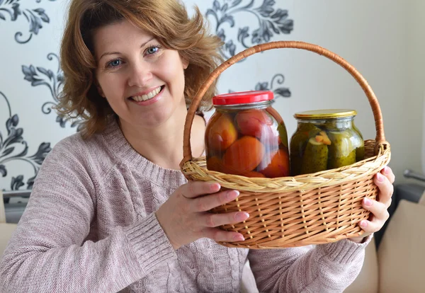 Домохозяйка с домашними консервированными овощами в номере — стоковое фото