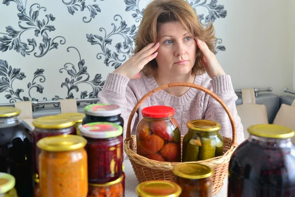 Femme fatiguée assise près de la maison en conserve pour l'hiver — Photo