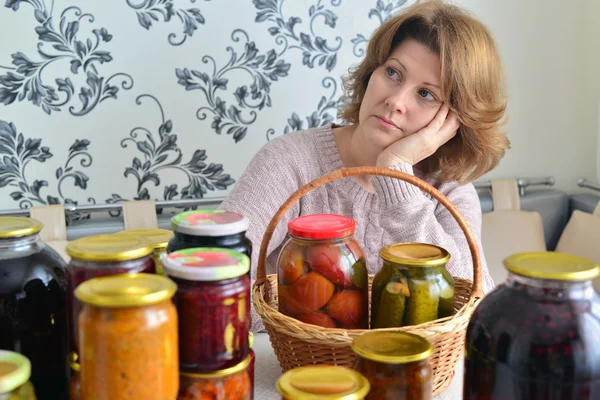 Müde Frau sitzt in der Nähe von zu Hause Konserven für den Winter — Stockfoto