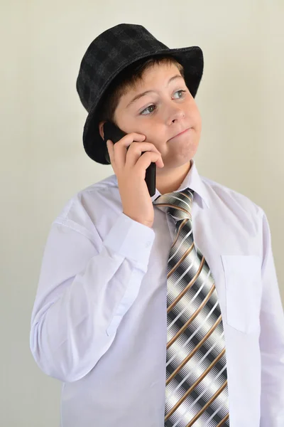 Teen pojke talar i mobiltelefon på ljus bakgrund — Stockfoto