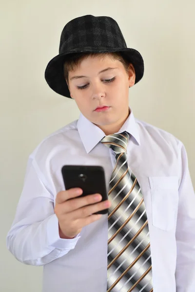 Tiener jongen met verbazing kijkt op mobiele telefoon — Stockfoto