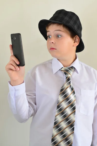 Teenie-Junge blickt überrascht aufs Handy — Stockfoto