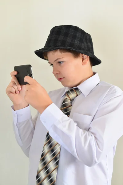 Adolescente menino com surpresa olha para o telefone móvel — Fotografia de Stock