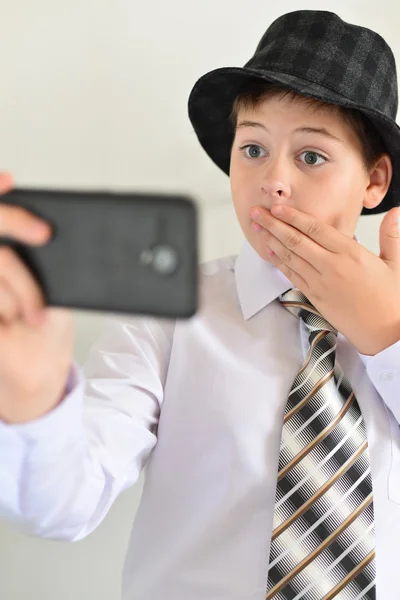 Teen pojke med förvåning ser på mobiltelefon — Stockfoto