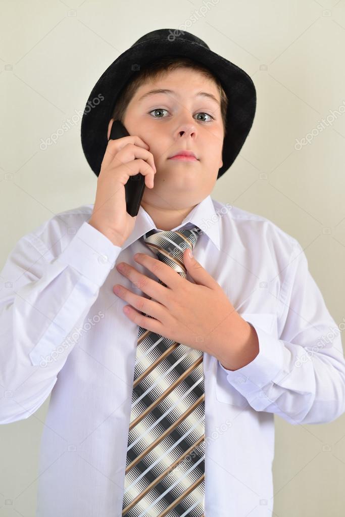 Teen boy talking on cell phone at  light background