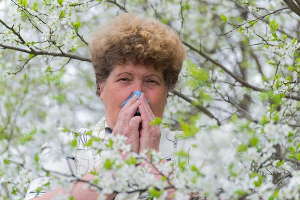 Kobieta z alergicznym nieżytem nosa w wiosenny ogród — Zdjęcie stockowe