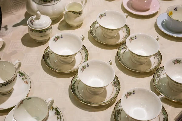 De nombreuses tasses à thé et soucoupes sont sur la table — Photo