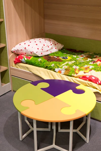 Fragment  interior children's room with a table in  form of  puzzle — Stock Photo, Image