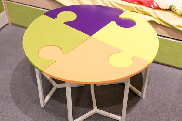 Фрагмент интерьера детской комнаты со столом в виде головоломки — стоковое фото