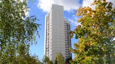 Yüksek katlı apartmanın sonbahar ağaçlarıyla çevrili