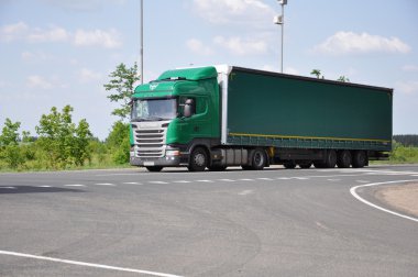 LIPETSK, RUSSIA - 29.05. 2015. Green Scania semi-trailer truck at  interurban road clipart