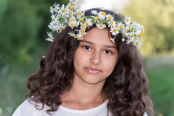 Teenager-Mädchen mit einem Kranz aus Gänseblümchen in der Natur — Stockfoto