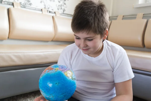 Garçon étudiant globe dans la chambre — Photo