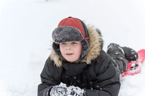 Teenage boy playing snow in winter Stock Picture