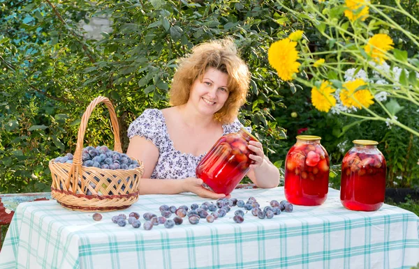 Donna con composta di prugne in giardino — Foto Stock