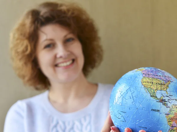 Жінка з глобусом в руках думає про подорожі — стокове фото