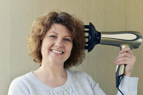 Wanita melakukan curls dengan pengering rambut dan diffuser — Stok Foto