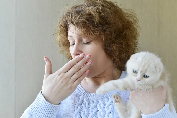 Woman with allergy is holding  kitten — Stock Photo, Image