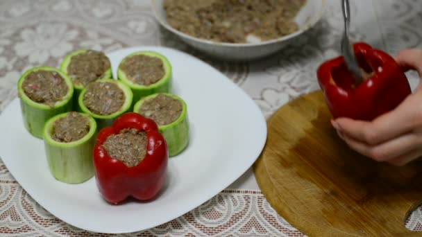 Vrouw bereidt courgette en peper gevuld met vlees — Stockvideo