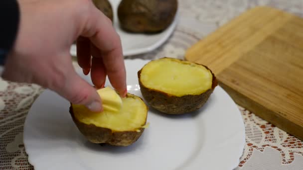 Mujer añade mantequilla en papas horneadas — Vídeo de stock