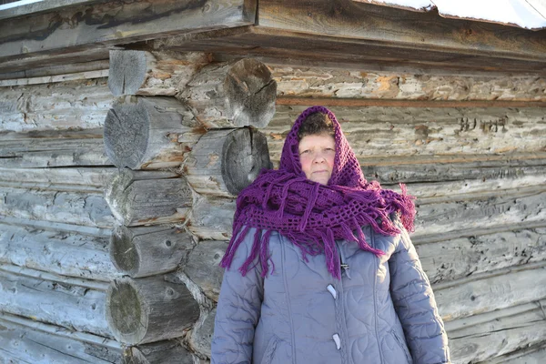 Die russische Frau in Schal wärmt die Hände in der Nähe einer Izba — Stockfoto