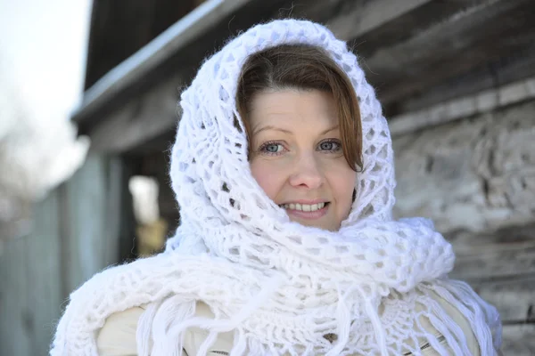 Den ryska kvinnan i sjal värmer händerna nära en izba — Stockfoto