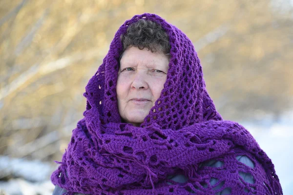 Пожилая женщина в фиолетовом трикотаже на голове — стоковое фото