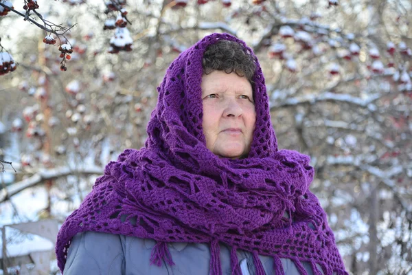 Пожилая женщина в фиолетовом трикотаже шаль на голове о Роуэн — стоковое фото