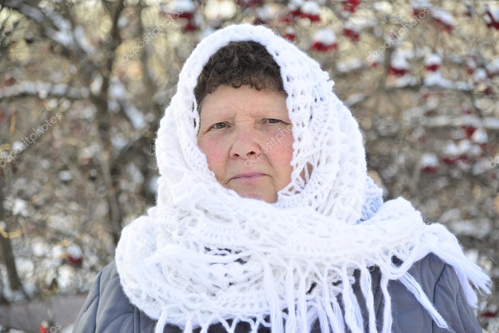 elderly woman in  white knitted shawl costs about Rowan