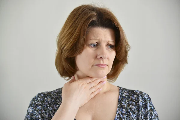 Donna adulta con mal di gola su sfondo chiaro — Foto Stock