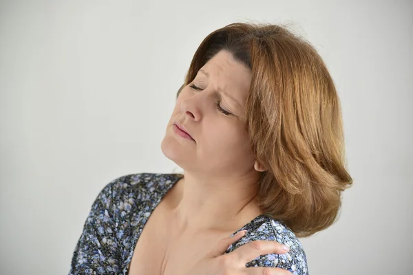 Woman with pain in his shoulder on light background — Stock Photo, Image