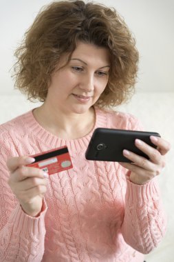 yetişkin kadın kredi kartı ile cep telefonunuzdan bir satın alma işlemi yaptığı