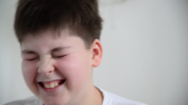 Tiener jongen antwoorden vragen, grimaces en lacht — Stockvideo