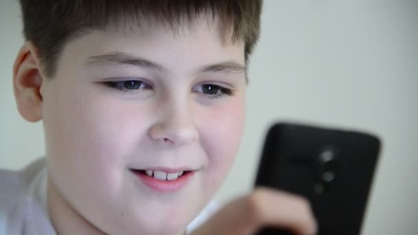 Menino joga no smartphone — Vídeo de Stock
