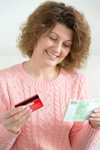 Adult woman holding money and credit cards — Stock Photo, Image