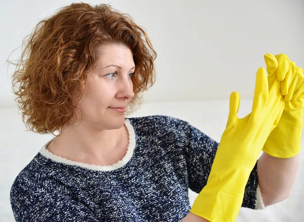 Woman takes off rubber gloves after cleaning — Stock Photo, Image