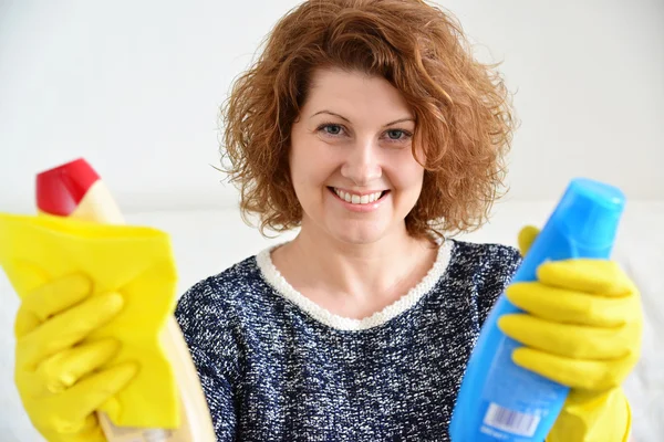 Happy woman in rubber gloves with cleaning agents — Stock Photo, Image