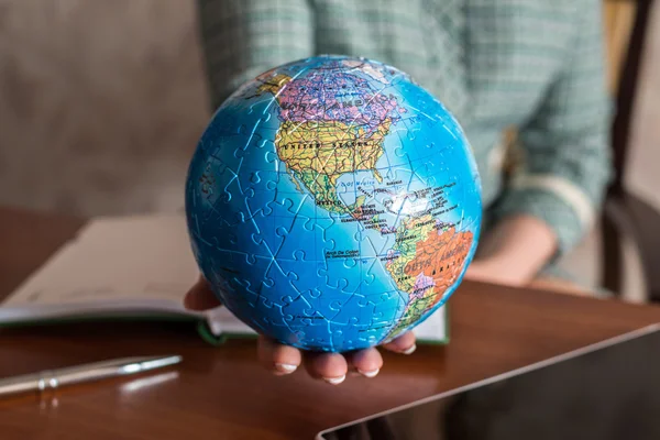 Sentada a la mesa mujer sosteniendo un globo — Foto de Stock