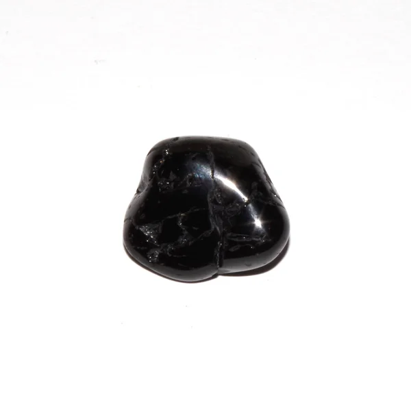 siyah turmalin (schorl) beyaz arkaplanda yuvarlanan taş 