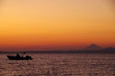 Şafak vakti kutsal Athos Dağı 'nın zeminine karşı balıkçı teknesi