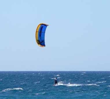 Mavi-sarı uçurtmalı Kiteboardcu 