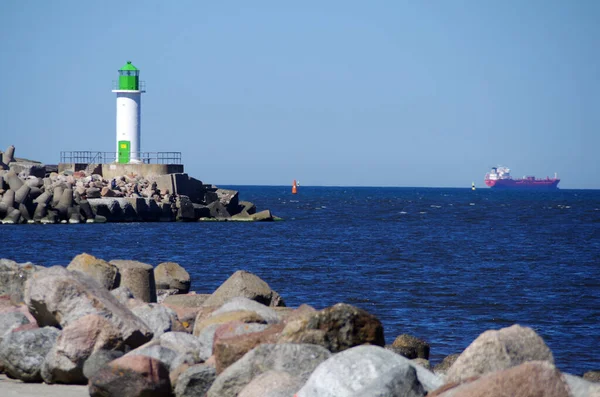 在大海和帆船的背景上的灯塔 — 图库照片