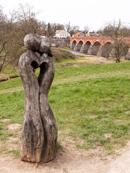 Деревянная Скульптура Влюбленной Пары Фоне Старого Каменного Моста Кулдига Латвия — стоковое фото