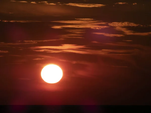 海面上的红色落日 天空和云彩的黑暗背景下的太阳 — 图库照片