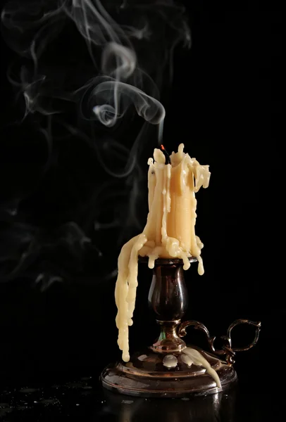 Vypalování staré svíčka vinobraní bronzový svícen. Na černém pozadí. Kouř. — Stock fotografie