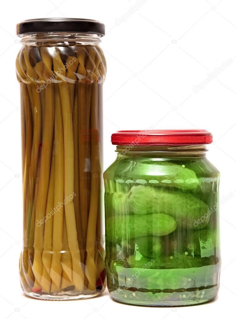 Preserved food in glass jars, isolated white background. Various marinaded . Wild garlic, cucumbers