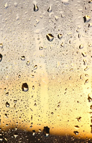 Chuva cai em vidro. O pôr do sol no fundo — Fotografia de Stock