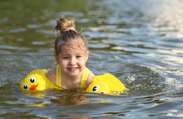 Niña nadando en el lago al aire libre. Retrato de cerca de la linda niña nadando, niño feliz divirtiéndose en el agua, resort de playa, vacaciones de verano y el concepto de vacaciones —  Fotos de Stock