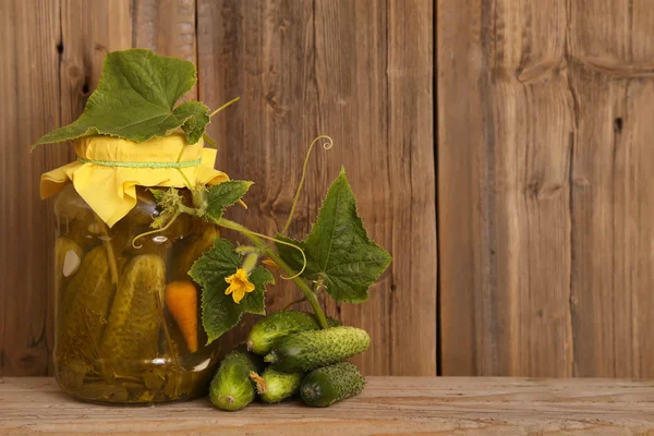 Domácí slané okurky ve skle jar čerstvé okurky. Sklenice Zeleninové konzervy, naturalné na dřevěné pozadí — Stock fotografie