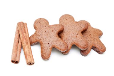 Zencefilli çörekler ve tarçın çubukları beyaz arka planda izole edilmiş.